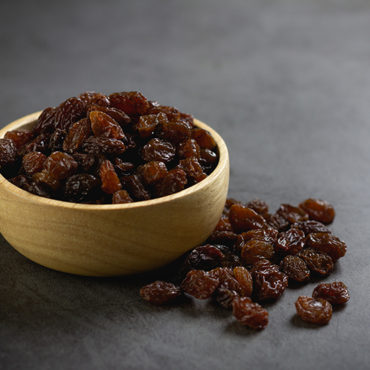 Dried raisins in bowl on table